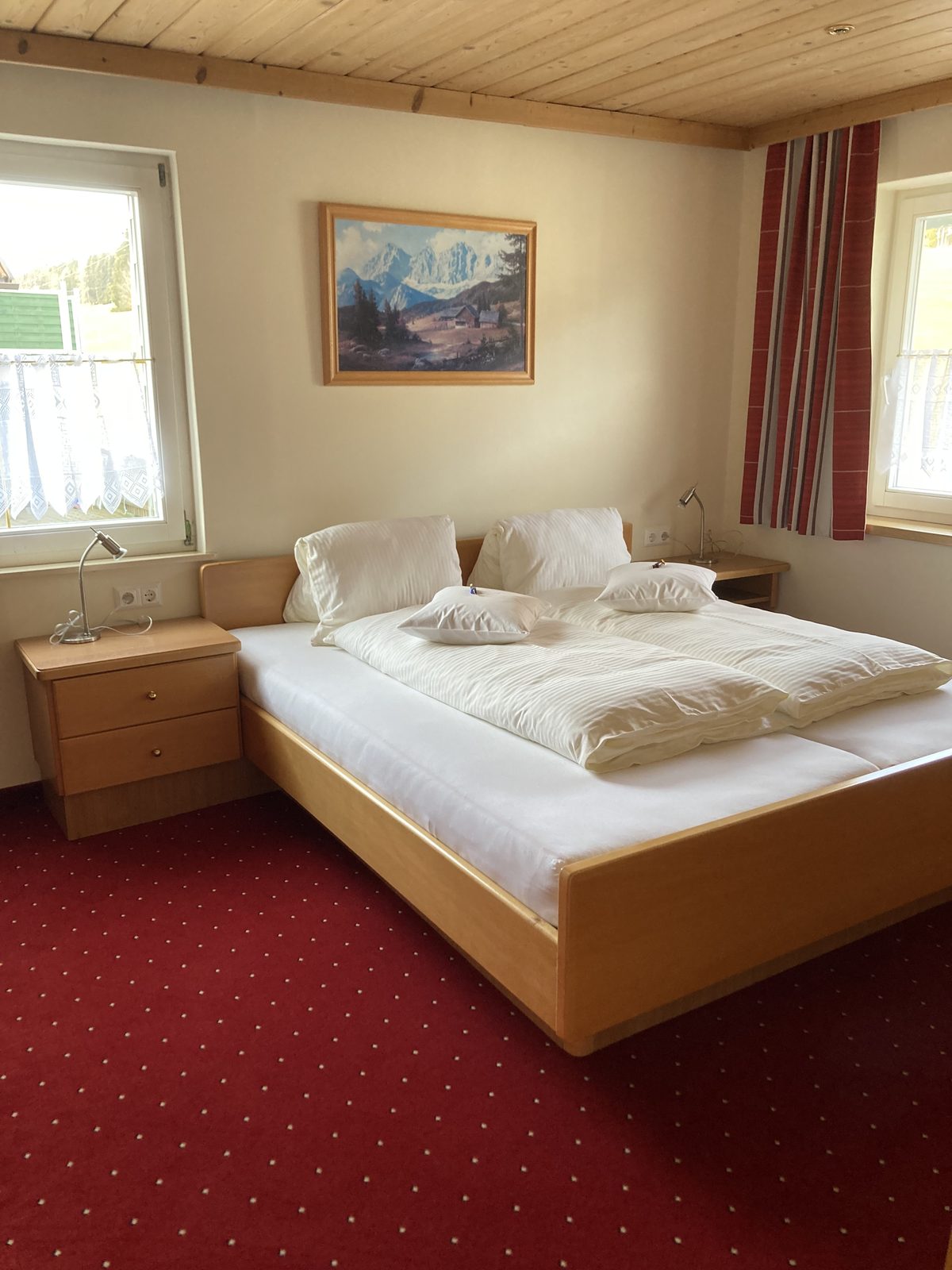 Gemütliches Doppelzimmer mit Nachtkästchen und Bergbild